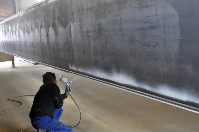 natryskowe malowanie stalowych belek w zakładzie przemysłowym